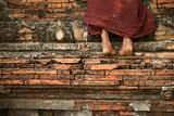 Buddhist novice monk climbing temple