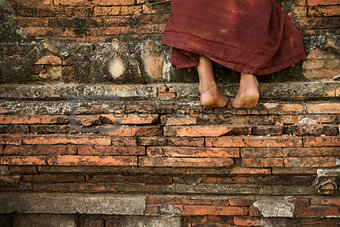 Buddhist novice monk climbing temple