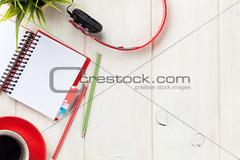 Desk with notepad, coffee and headphones