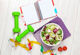 Dumbells, tape measure, healthy food and notepad for copy space