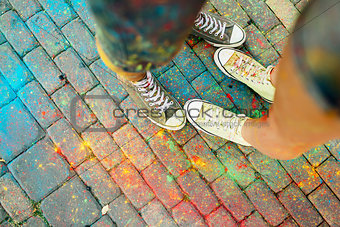 Close-up of feet on the ground surrounded by paints