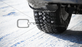 Close-up Image of Winter Car Tire on Snowy Road. Drive Safe Concept