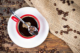 Coffee beans on spoon on top of coffee cup