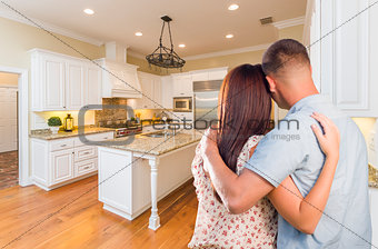 Young Hopeful Military Couple Looking At Custom Kitchen