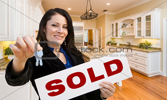 Hispanic Woman In Kitchen Holding House Keys and Sold Sign