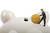 Businessman putting big coin in piggy bank