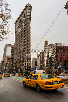 Yellow taxi and Flatiron building at Fifth Avenue av in Manhattan
