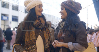 Two women chatting at a street in winter