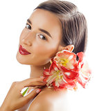 young pretty brunette woman with red flower amaryllis close up isolated on white background. Fancy fashion makeup, bright lipstick, creative Ombre manicured nails