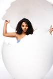 black skined woman in big crashed egg. modern easter hipster concept