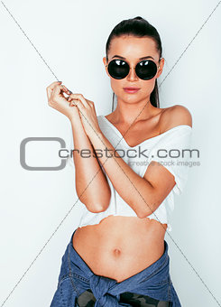 young pretty brunette girl hipster with makeup on white background casual close up dreaming isolated smiling cool wearing sunglasses