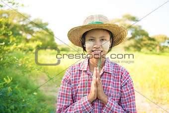 Traditional young Myanmar female farmer greeting