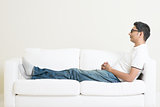Asian man resting and daydream on couch