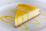 Lemon cheese cake with sauce on a white plate