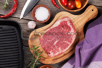 Raw beef steak and spices on wooden table