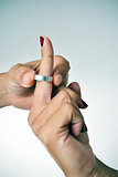 man putting on or putting off a ring from the finger of a woman