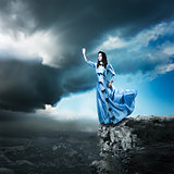 Woman in Blue Dress Reaching for the Light