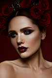 Beauty fashion model girl with dark makeup and roses in her hair