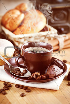 Cup hot coffee with beans and chocolate candies
