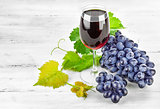 Glass red wine with cluster grapes
