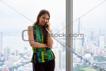 Young Latina Businesswoman With Wired Telephone In Modern Office