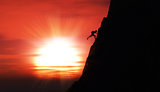 Extreme rock climber against a sunset sky