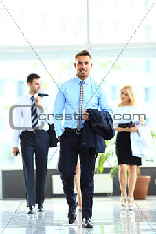 businesspeople group walking at modern bright office interior
