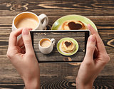 Hands taking photo pancakes with smartphone