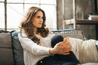 Portrait of young weatlhy woman sitting on couch and dreaming