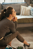 Photo of stylish brunet woman sitting in loft living room