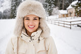 Portrait of happy young woman in furry hat in winter outdoors