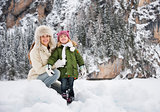 Portrait of happy mother and child in front of snowy mountains