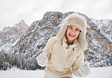 Portrait of cheerful young woman in fur hat in winter outdoors