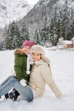 Happy mother and child outdoors in front of snowy mountains