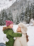 Mother and child playing outdoors in front of snowy mountains