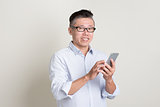 Portrait of mature Asian man using smart phone