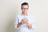Mature Asian man using smart phone