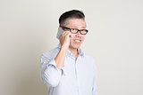 Mature Asian man making call on smart phone