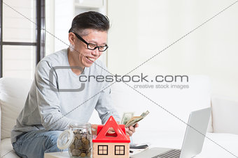 Mature Asian man counting on money