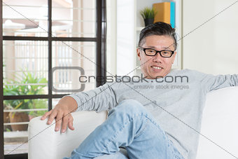 Mature Asian male sitting at home.