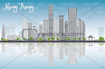 Hong Kong skyline with grey buildings and blue sky.