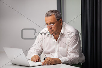 Senior businessman working with laptop in office