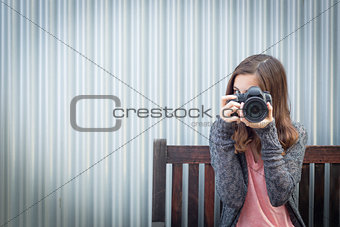 Girl Photographer Sitting and Pointing Camera