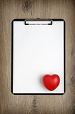 Clipboard with blank white paper and heart shape