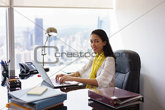 Business Woman Assistant Typing On PC And Smiling At Camera