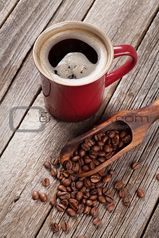 Coffee cup and beans on wooden table