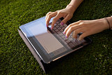 Woman Emailing And Texting With Tablet Computer On Grass