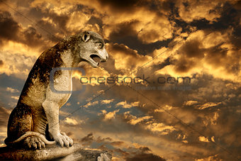 Sunset, ancient lion statue and storm sky