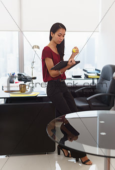 Nervous business woman with anti stress ball holds tablet