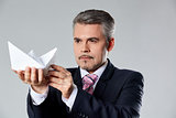 Portrait of businessman holding paper boat